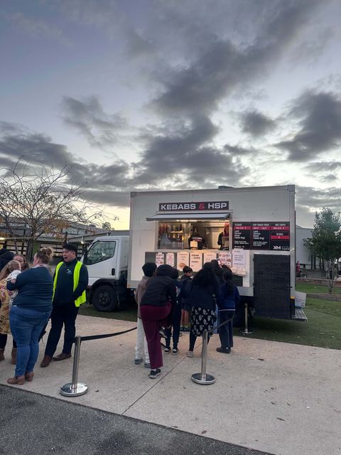 Guests queuing at the Kebabman truck at an evening event