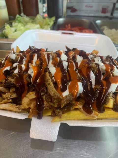 A loaded HSP in a box with chips, meat and sauces