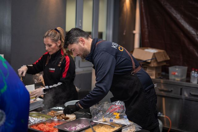 Two of the team preparing food at a pop-up kebab setup