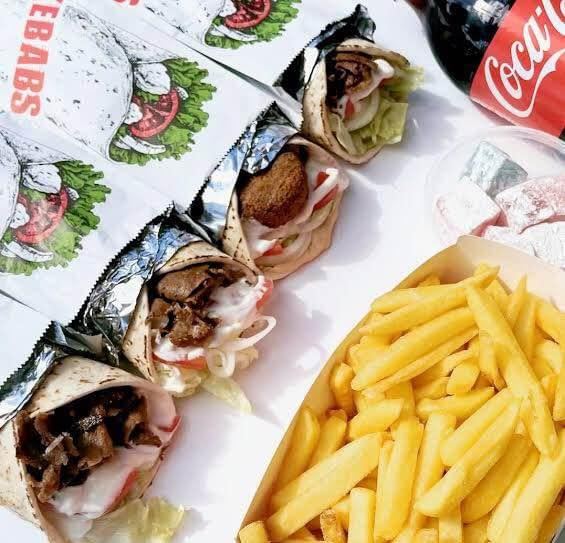 Kebab wraps and a tray of hot chips with a drink